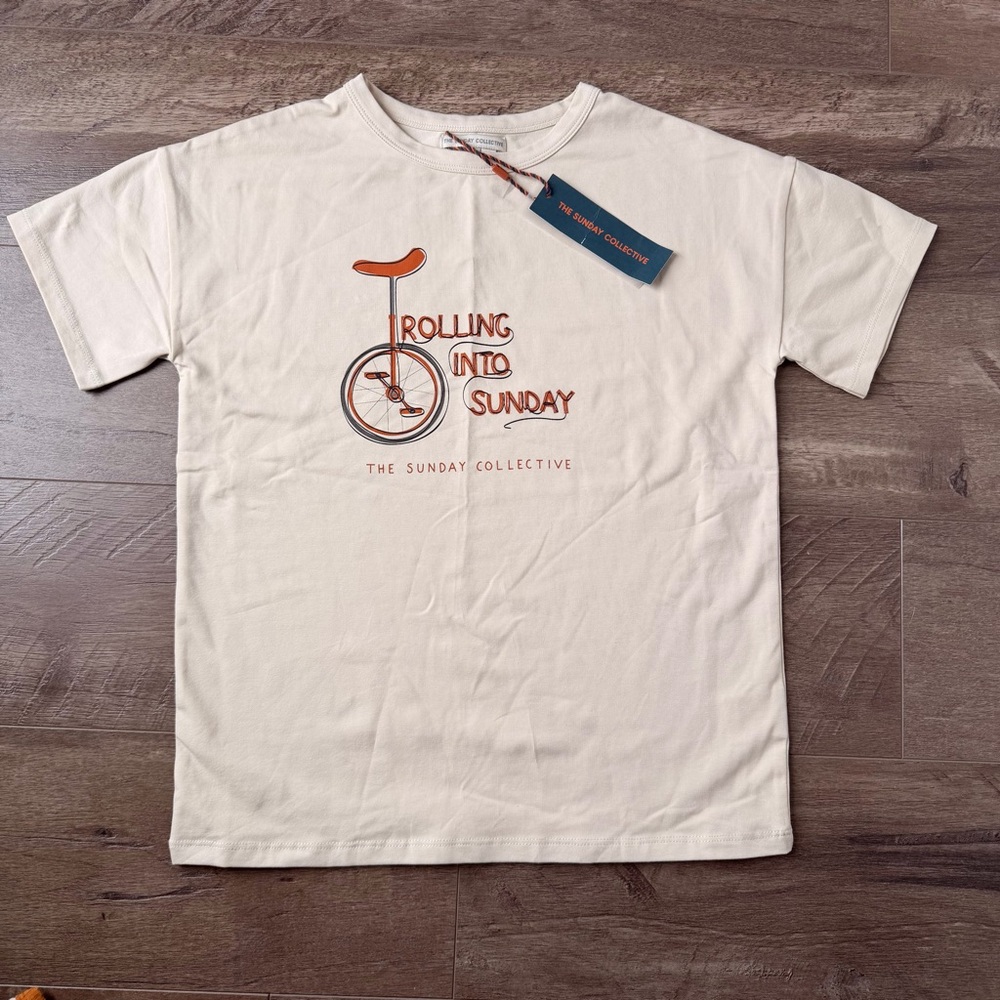 8Y Sunday Collective Cream Tee with Orange Unicycle Graphic